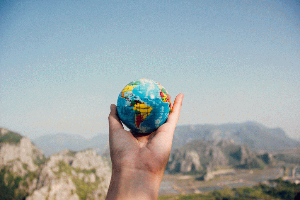Travel Agent Near me. A photo of a hand holding a small earth globe